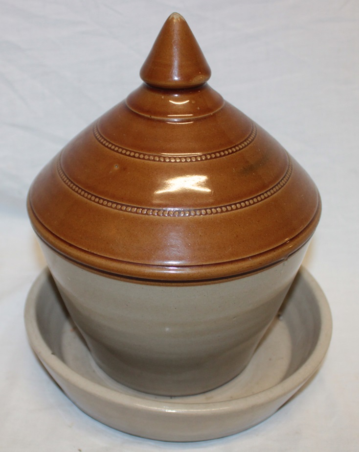 An old stoneware two-piece poultry drinker with tapered cover,
