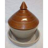 An old stoneware two-piece poultry drinker with tapered cover,