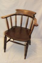 An elm and beech captain's-style armchair with spindle back and shaped seat on turned legs