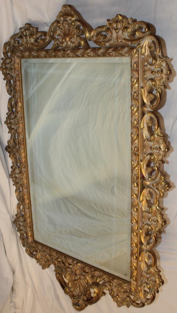 A modern ornamental rectangular wall mirror in gilt scroll frame,