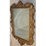 A modern ornamental rectangular wall mirror in gilt scroll frame,