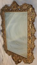 A modern ornamental rectangular wall mirror in gilt scroll frame,