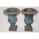 A pair of small cast iron classical-shaped garden urns with fluted columns and square bases,