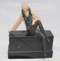 A modern Art Deco-style bronzed spelter figure of a seated female with composition arms and head on