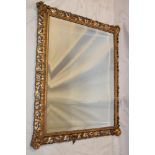 A bevelled rectangular wall mirror in gilt pierced and scroll decorated frame,