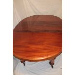 A Victorian walnut circular extending dining table with one additional centre leaf on turned