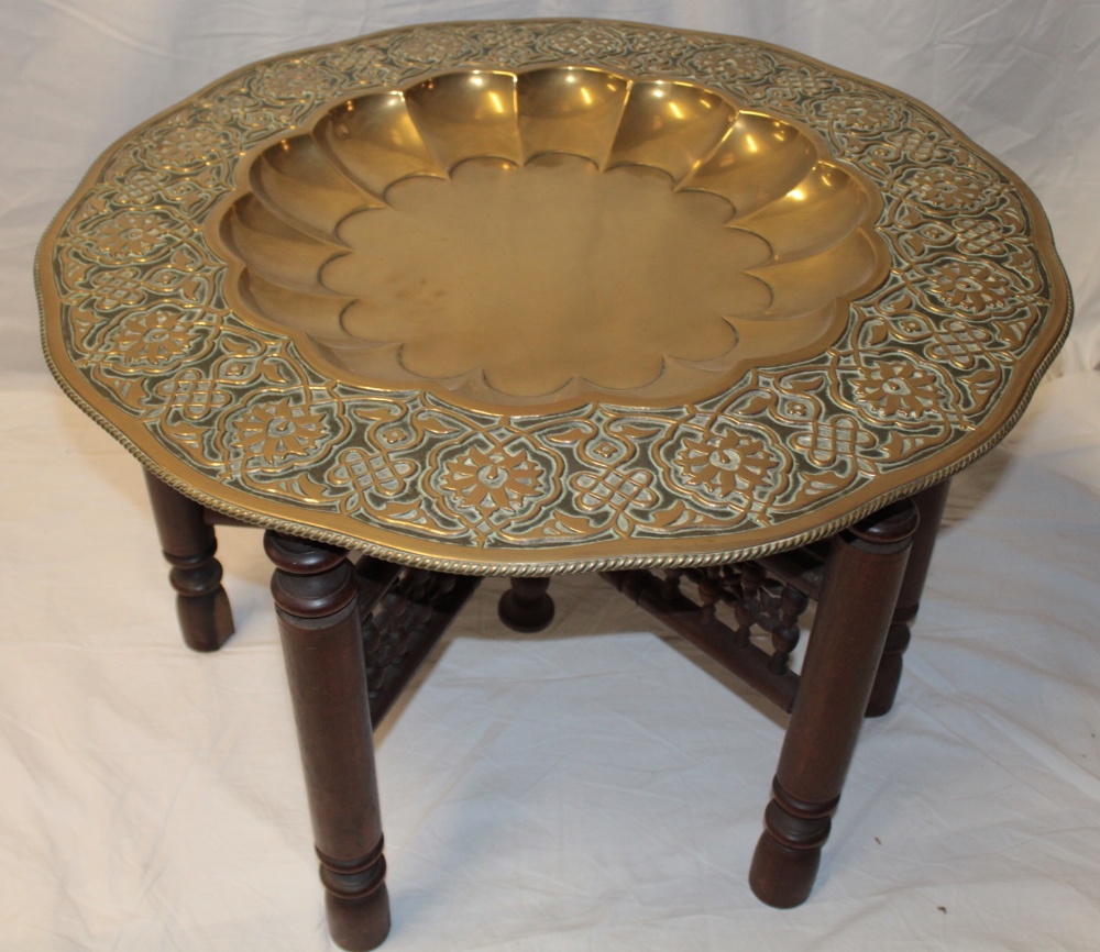 A large Indian brass top occasional table with recessed centre and floral decorated borders,