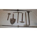 A selection of old Cornish mining tools including two iron pry bars, a pick, hammers etc.
