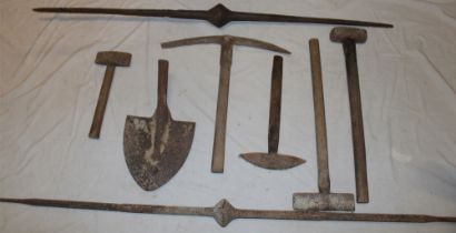 A selection of old Cornish mining tools including two iron pry bars, a pick, hammers etc.