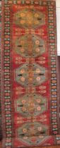 An Eastern-style wool runner with geometric decoration on red and blue ground,