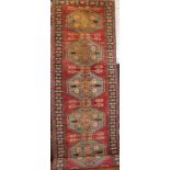 An Eastern-style wool runner with geometric decoration on red and blue ground,