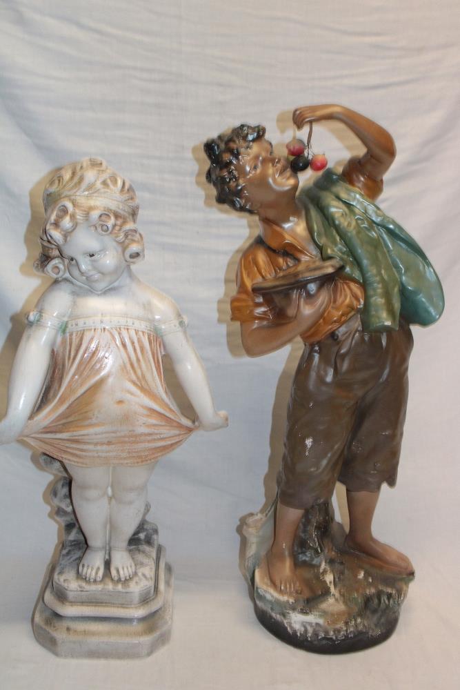 A 1930's plaster figure of a boy eating cherries,