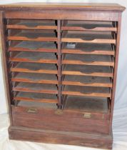 A 1920's/30's oak filing cabinet with a double bank of sliding trays enclosed by a tambour shutter