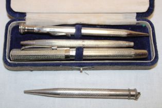 A silver cased propelling pencil and three other various pens/pencils