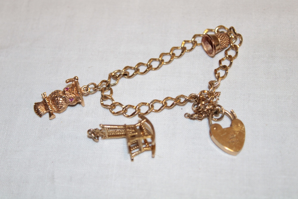 A 9ct gold chain link bracelet with 9ct padlock clasp supporting three 9ct gold charms (12g)