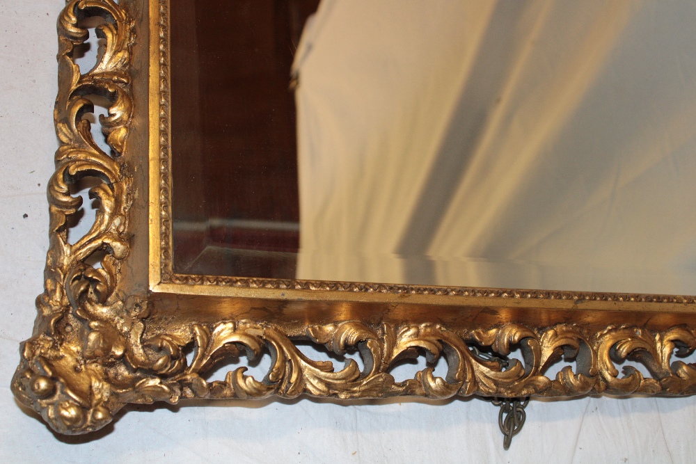 A bevelled rectangular wall mirror in gilt pierced and scroll decorated frame, - Image 2 of 2