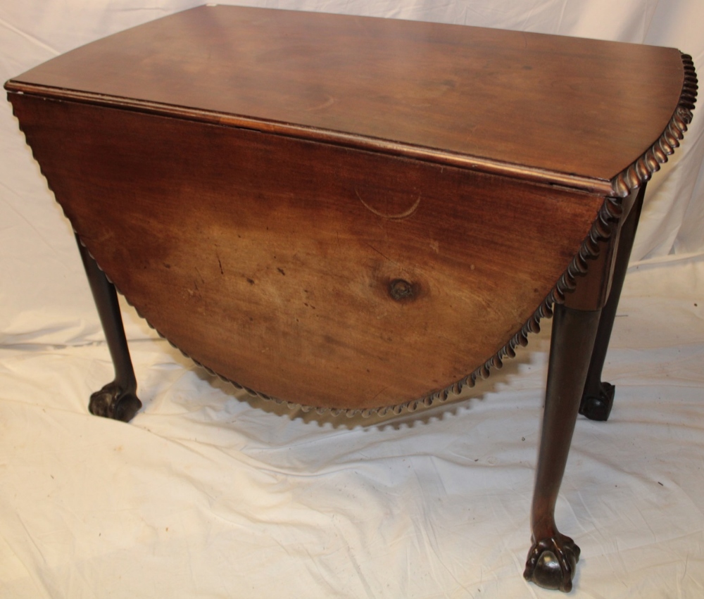 An Edwardian mahogany oval drop-leaf dining table with decorated edge on turned legs with claw and - Image 2 of 2