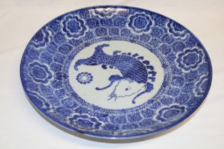 A 19th century Japanese pottery circular charger with blue and white fish and floral decoration,