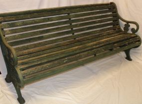 A Victorian garden bench with cast-iron pierced ends and slatted body,