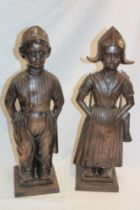 A pair of bronzed metal companion stands in the form of Dutch boy and girl,