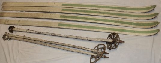 Two pairs of vintage painted wood skis and accompanying sticks