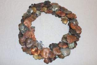 A Cornish art metal circular wall plaque in the form of copper and steel leaves,