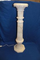 An unusual carved and polished white marble torchere with fluted column and octagonal base,