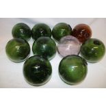 Ten various Cornish glass fishing floats in green, amber and pink tinted glass,