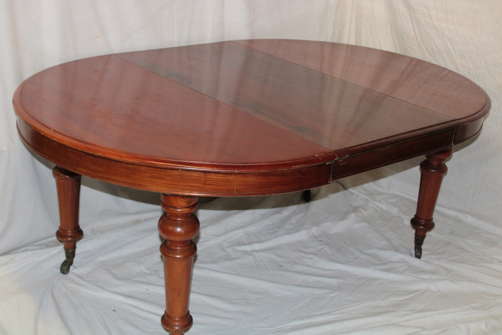 A Victorian walnut circular extending dining table with one additional centre leaf on turned - Image 2 of 2