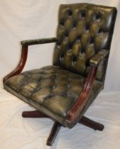 A reproduction mahogany swivel easy/office chair upholstered in green buttoned leather