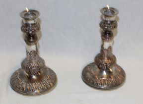 A pair of Sheffield plate candlesticks with raised tapered stems on circular bases,