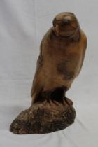 A rustic carved wood figure of a falcon,