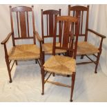 A pair of Arts and Crafts oak carver armchairs with rush-work seats on turned legs together with a