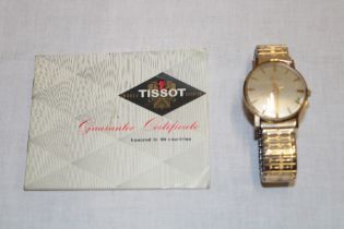 A gentleman's 9ct gold wristwatch by Tissot with expanding strap and original certificate