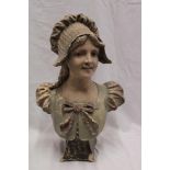 A Continental painted plaster bust figure of a female wearing a bonnet,