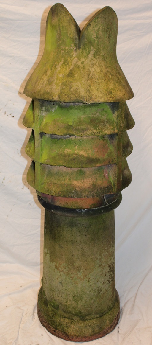 A weathered terracotta two-piece chimney pot,