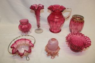 A selection of Victorian and later cranberry tinted glass ware including tapered spill vase,