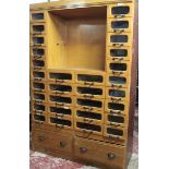 A good quality ash shop full length millinery cabinet with two base drawers below an arrangement of