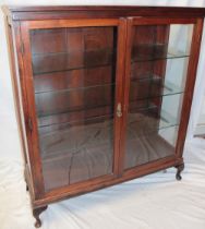 A good quality polished mahogany display cabinet with glass shelves enclosed by two glazed doors on