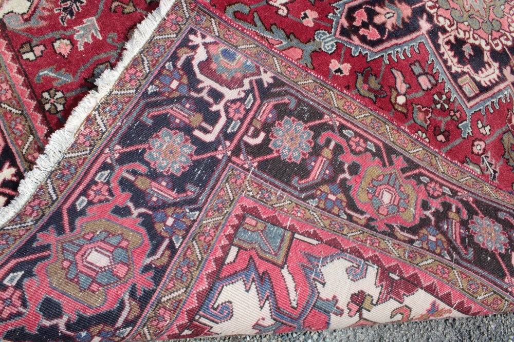 An small Eastern-style wool carpet with geometric and floral decoration on red ground 118" x 80" - Image 2 of 2