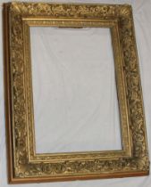 A 19th century gilt rectangular picture frame with raised scroll and floral decoration 43" x 33"