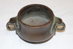 A small 19th century Japanese bronze circular two-handled incense pot,