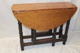 A Charles II and later oak oval gate-leg dining table on bobbin turned supports,