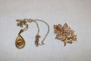 An oval pendant set citrine with 9ct gold chain and a 9ct gold leaf pattern brooch (2)