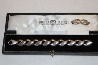 A modern silver bracelet by Brett Payne in the form of swans with 9ct gold heads together with a