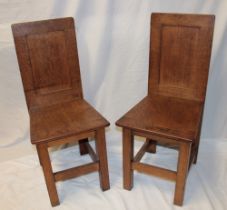 A pair of oak rustic hall chairs with plain panelled backs on square-shaped legs