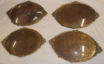 A set of four unusual brass oval picture frames with raised scroll mounts and bow glass 24" x 15"