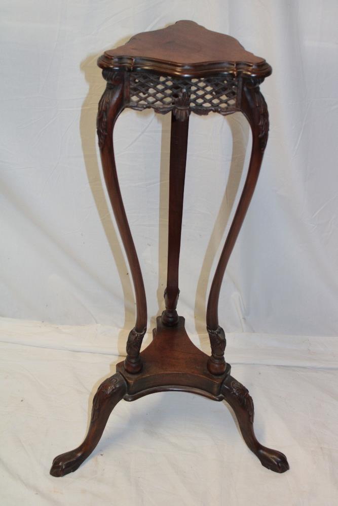 An Edwardian carved mahogany triangular plant stand on scroll-shaped legs (af)