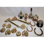 Two old brass horse singeing combs, a selection of various horse brasses, horse harness bells,