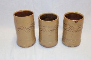 Three Wenford Bridge studio pottery cylindrical vases by Seth Cardew with wavy line decoration on